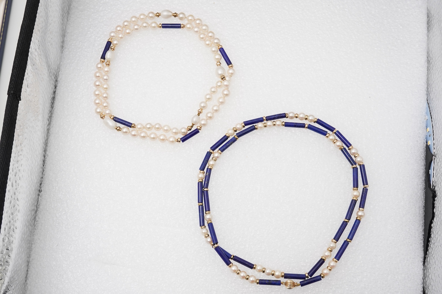 Two cultured pearl, lapis lazuli and gold necklaces, each composed of lapis lazuli batons and cultured pearls, with gold spacers, lengths 77.5cm and 64cm